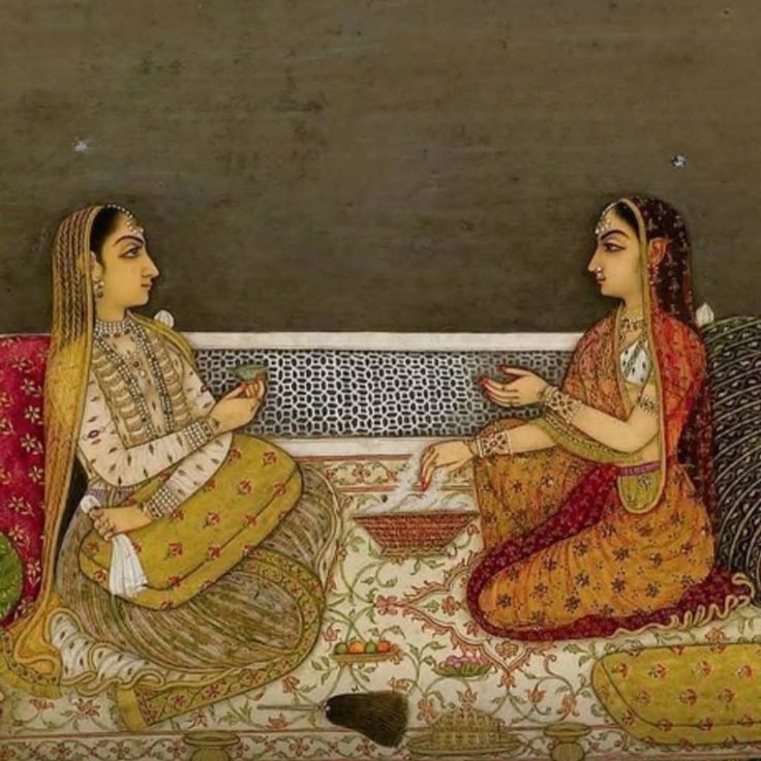 A Mughal miniature of two women seated facing each other in conversation.