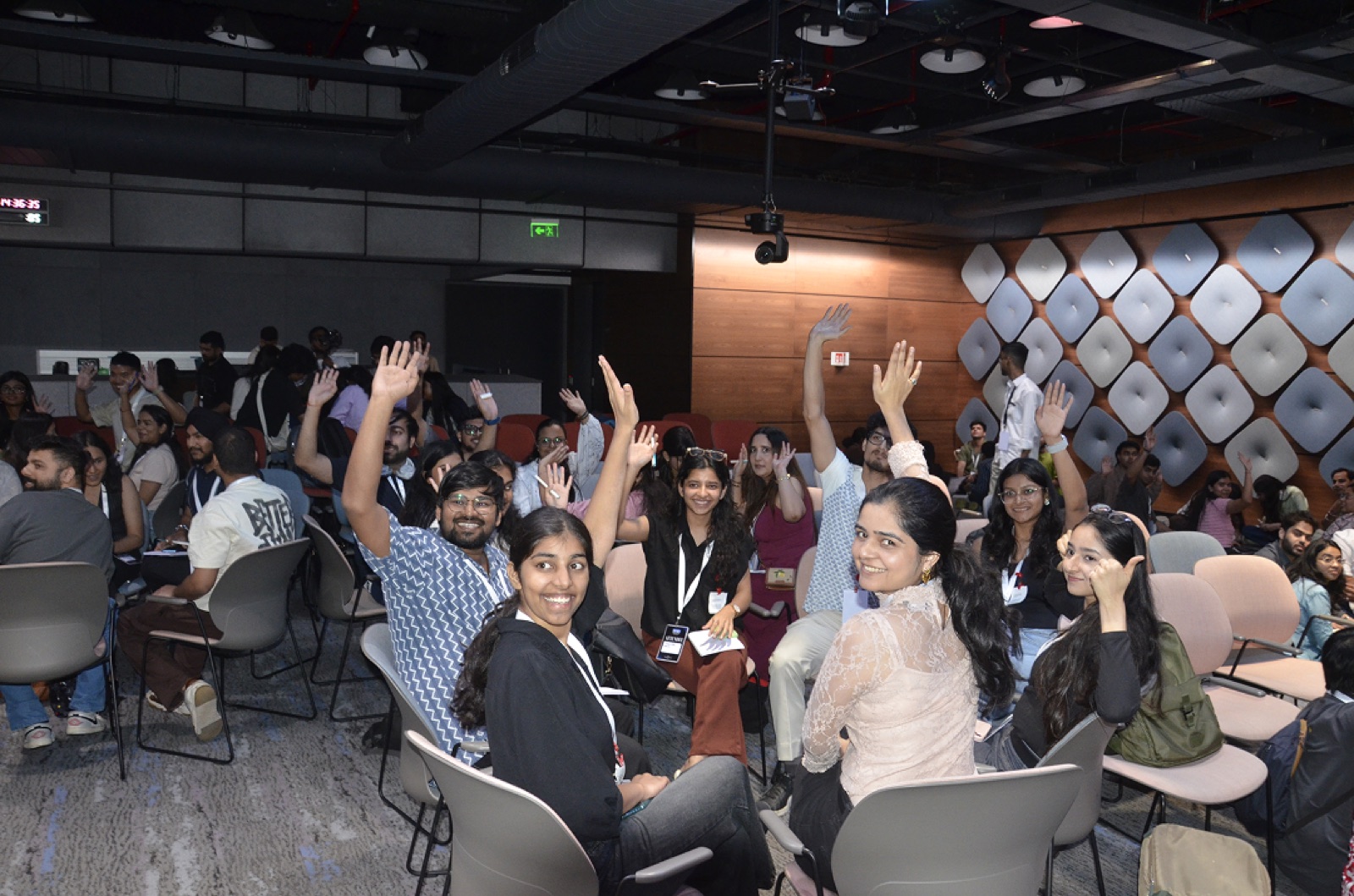 Hands go up across the audience during a talk