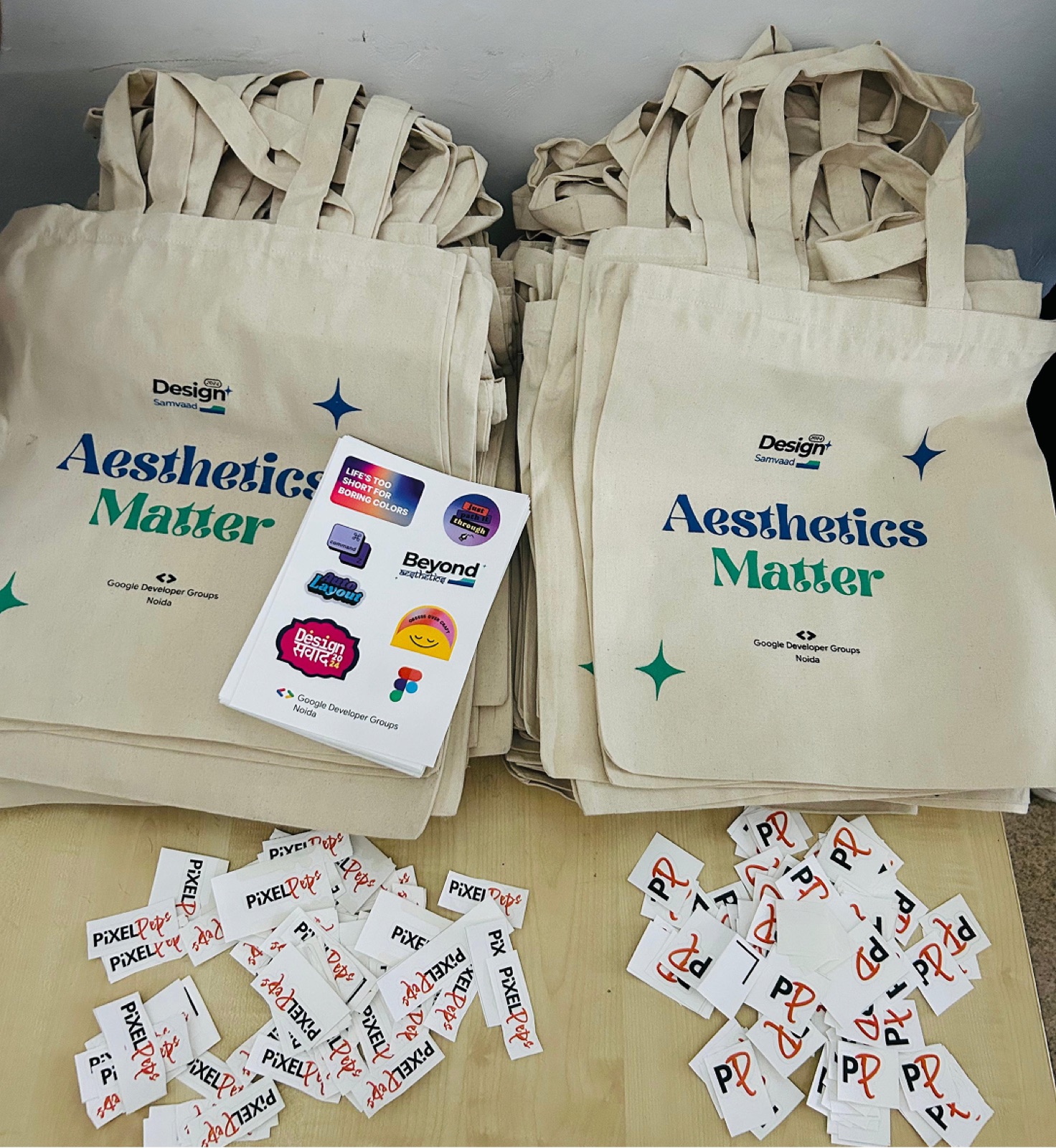 Stacks of 'Aesthetics Matter' tote bags and sticker sheets before doors open